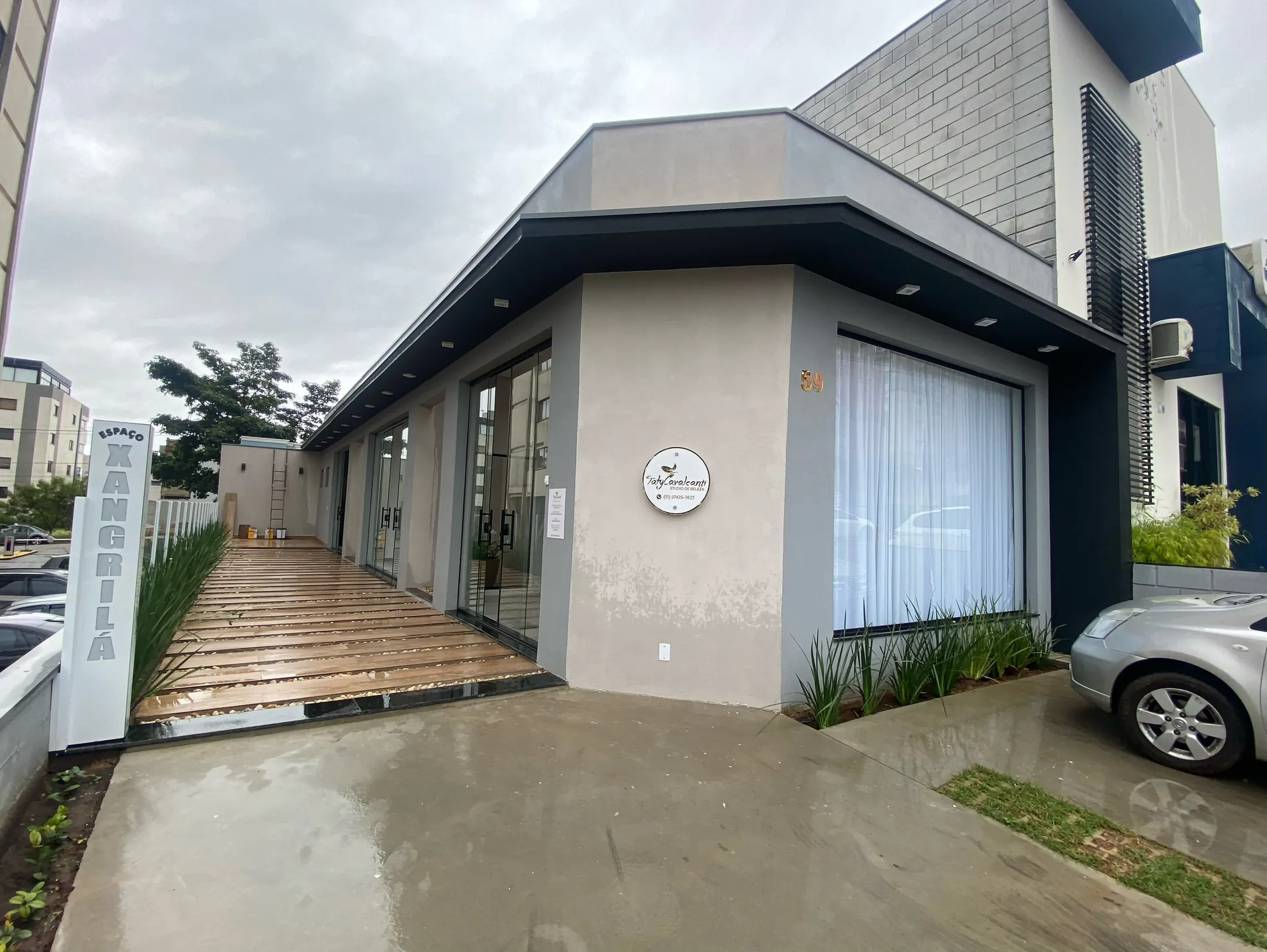 Fachada comercial com janelas amplas e deck de madeira na entrada, obra entregue